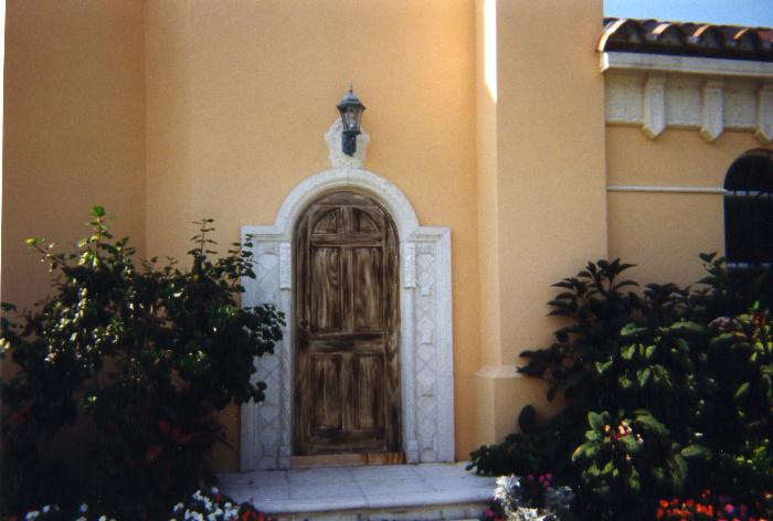 Cast Stone enterance garage with faux finished door.
